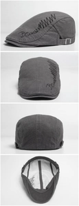 Detail view of cotton beret featuring side embroidery and adjustable metal buckle