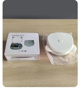 White cat-ear cosmetic storage box with mirror on a wooden desk with its packaging