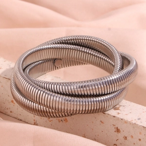 Detail of silver multi-layer spiral snake chain bracelet on natural stone base
