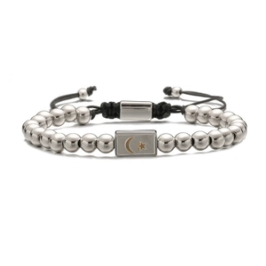 Detail of hand-woven bracelet with silver moon and star beads on black adjustable cord