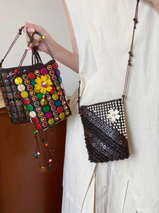 Detail of bohemian hand-woven coconut shell bead crossbody bags with flower patterns