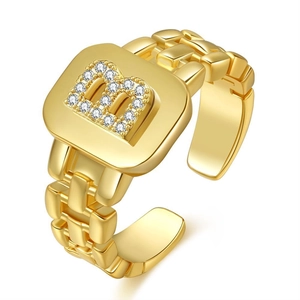 Macro detail of gold-plated open ring with crystal-studded letter B and curb chain band