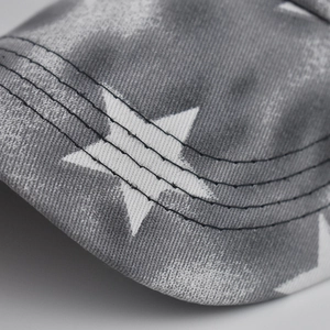 Macro shot of grey star print on cotton twill fabric with four-row reinforced stitching