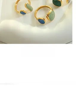 Detailed close-up of vintage gold rings with colorful enamel square beads on stone