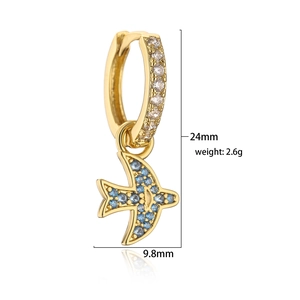 Macro view of detailed bird drop earring featuring blue zircons and 18K gold plating