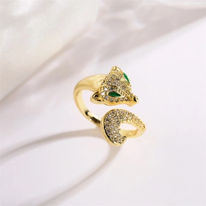 Macro d'une bague renard dorée avec zircons pavés et yeux en pierres vertes