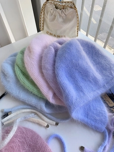 Detail von flauschigen Angora-Kaninchenhaar-Hüten in Pastellfarben mit Bindebändern