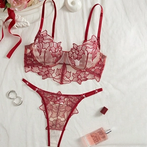 Detailed flat lay of red floral embroidery lace bra and thong with diamond accents