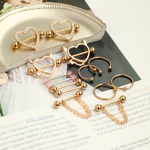 Flat lay of assorted stainless steel nipple rings with gold finish and crystal details