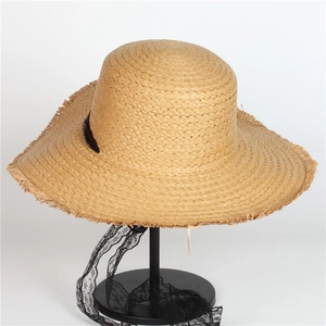 Handcrafted straw sun hat with wide frayed brim and black lace ties for beach vacation