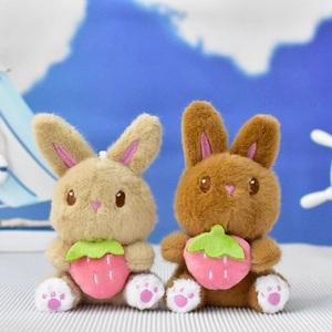 Close-up of two cute plush rabbit keychains holding strawberries in tan and brown