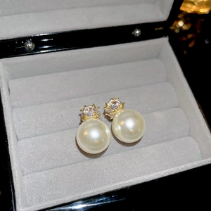 Vue macro de boucles d'oreilles perles et zircon carré sur boîte en velours gris