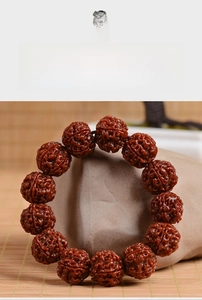 Detailed close-up of polished Nepalese Rudraksha beads on a stone base with bamboo mat