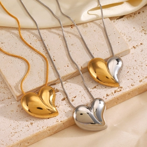 Collane con ciondolo a cuore in oro e argento con catena a serpente su pietra beige