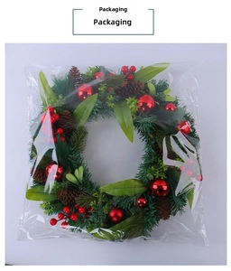 Christmas wreath packaging with pine needles, red berries, and cones in clear bag