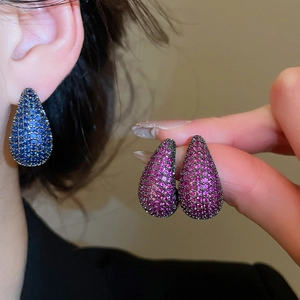 Detail of blue and pink waterdrop stud earrings with micro pavé settings on person