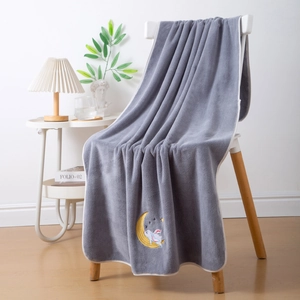 Grey coral fleece bath towel with moon and rabbit embroidery hanging on chair