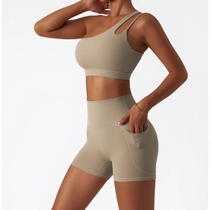 Detail of khaki one-shoulder yoga bra and high-waist sports shorts with side pockets
