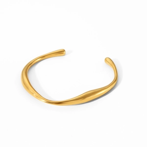 Detailed close-up of golden irregular wavy stainless steel bangle with polished finish