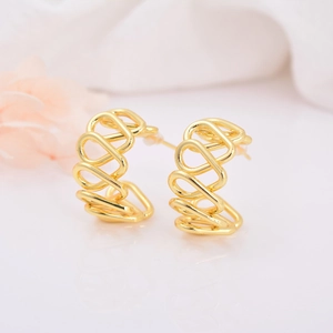Macro detail of 18k gold plated C-shape hollow heart earrings with wavy geometric design