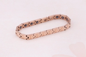 Makro-Detail von roségoldenem Magnetarmband mit eingelegten schwarzen Germaniumsteinen