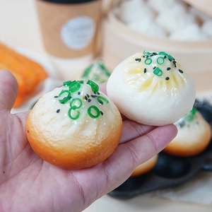 Realistic PVC steamed bun and fried baozi keychain models held in hand for size