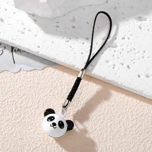 Detail of cute metal panda bell charm with black cord for phone or bag decoration