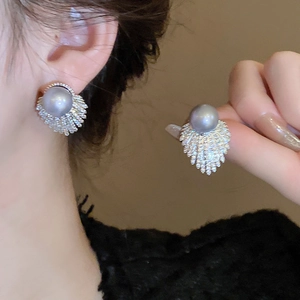 Detail of grey-purple pearl earring with fan-shaped zircon setting and silver needle