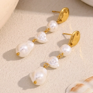 Detail of 18K gold-plated irregular metal earrings with three baroque pearl pendants