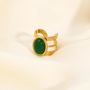 Detailed macro view of an adjustable gold-plated ring with a green stone inlay
