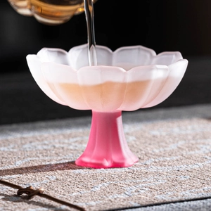 Pink frosted petal glass stemware cup with liquid pouring into the flower shaped bowl