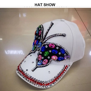 Detail of colorful rhinestone butterfly design and red crystal trim on white baseball cap