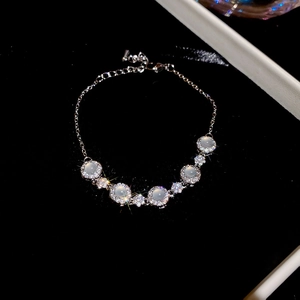 Détail d'un bracelet en argent avec fleurs en zircon et opales sur fond de velours noir