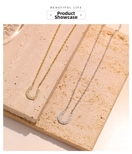 Close-up of gold and silver horseshoe necklaces with micro-pave crystals on stone