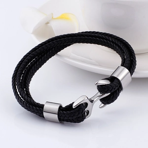 Close-up of a black braided multi-layer leather bracelet with a silver anchor clasp