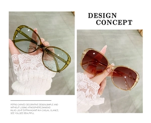 Detail of olive green and amber tea oversized sunglasses with thick retro frames