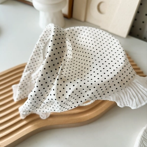 Détail d'un serre-tête blanc à pois avec bords à volants et esthétique rétro chic