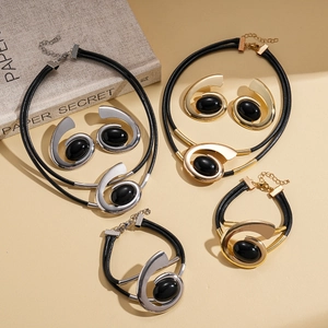 Modern gold and silver jewelry sets with black oval gems and spiral metal accents