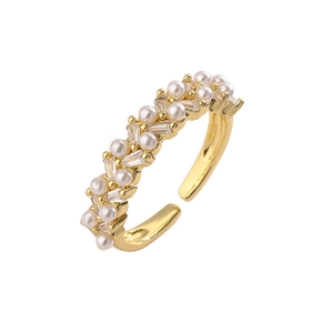 Detail of adjustable gold ring with small white pearls and baguette zirconia crystals