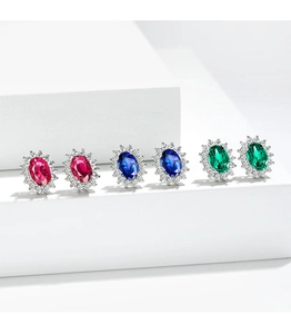 Detail view of oval cut sapphire, ruby and emerald stud earrings with cubic zirconia halo