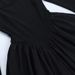 Détail des plis à la taille et de la texture mate de la robe bouffante noire chic