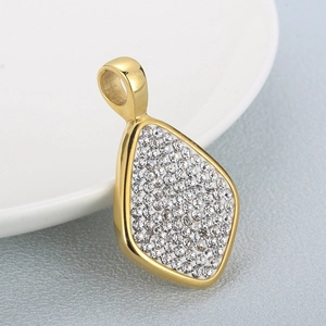 Detail of a gold-plated rhombic pendant with pavé white rhinestones on white ceramic