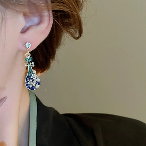 Close-up of elegant Chinese style pipa earrings with enamel, pearls and rhinestones on model