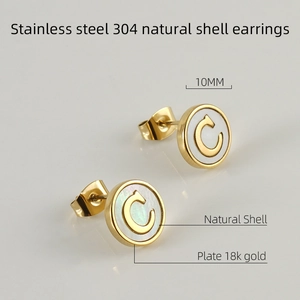 Detail of 10mm stainless steel earrings with white shell and golden letter C design