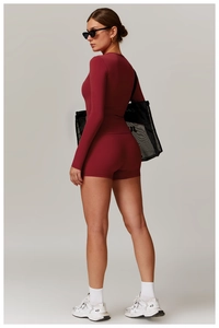 Vue latérale de l'ensemble de yoga bordeaux avec haut à manches longues et short