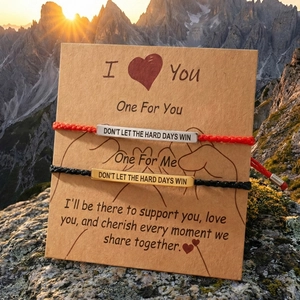 Bracelets de couple inspirants avec plaques gravées sur fond de montagnes au coucher du soleil