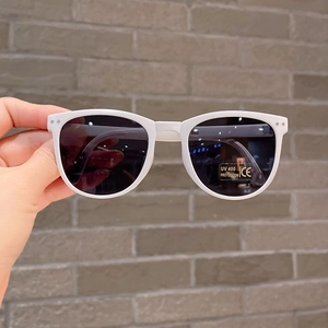 Close-up of white foldable sunglasses showing UV400 protection and CE certification marks