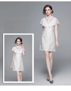 Détail de la robe jacquard blanche avec encolure en dentelle et nœud à volants