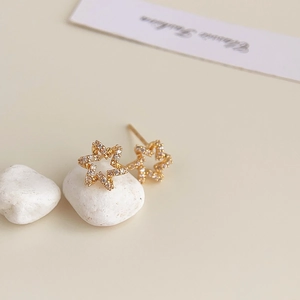 Macro shot of 18K gold plated star stud earrings with sparkling cubic zirconia inlay