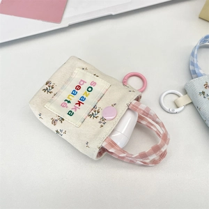 Close-up of floral canvas earbud case with pink snap button and hook attachment